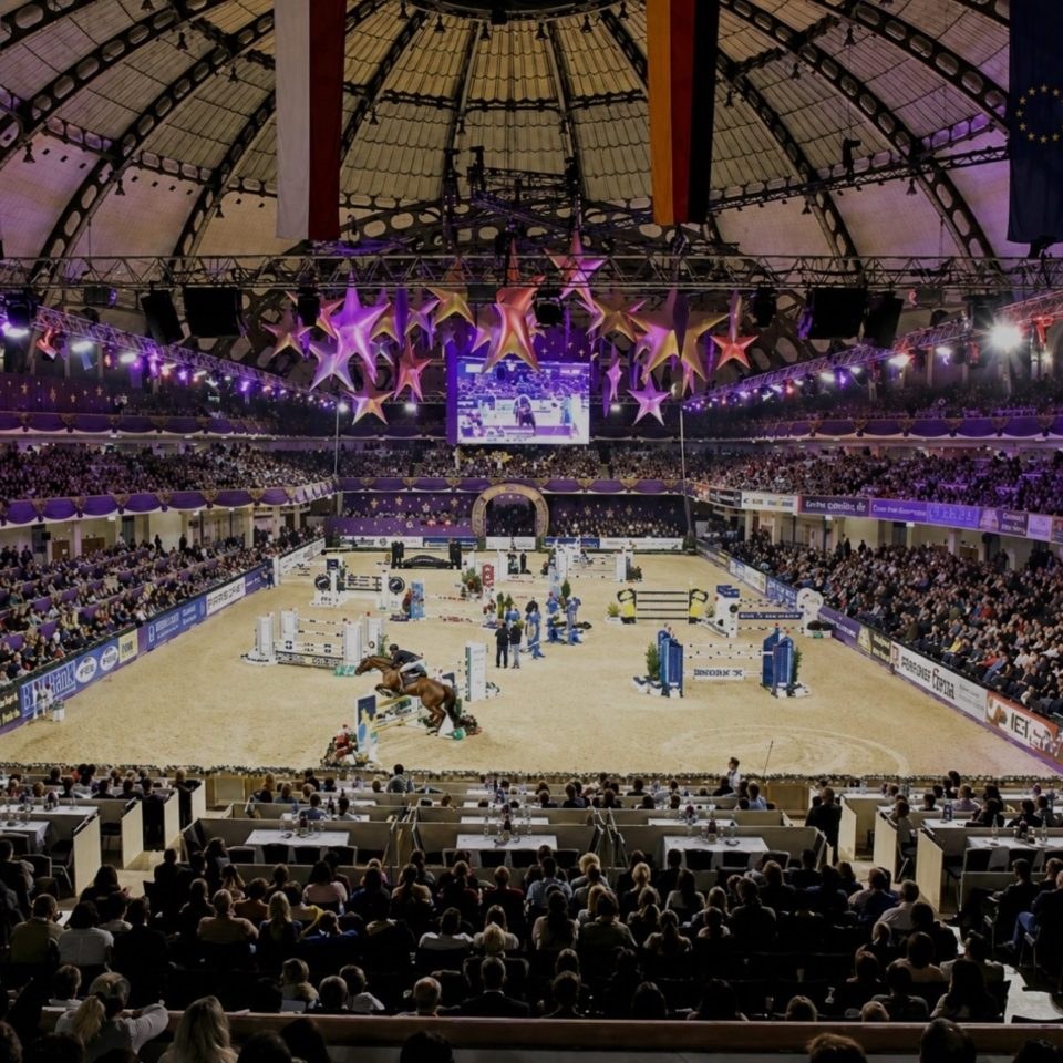 Reitturnier in einer Halle mit vollen Rängen